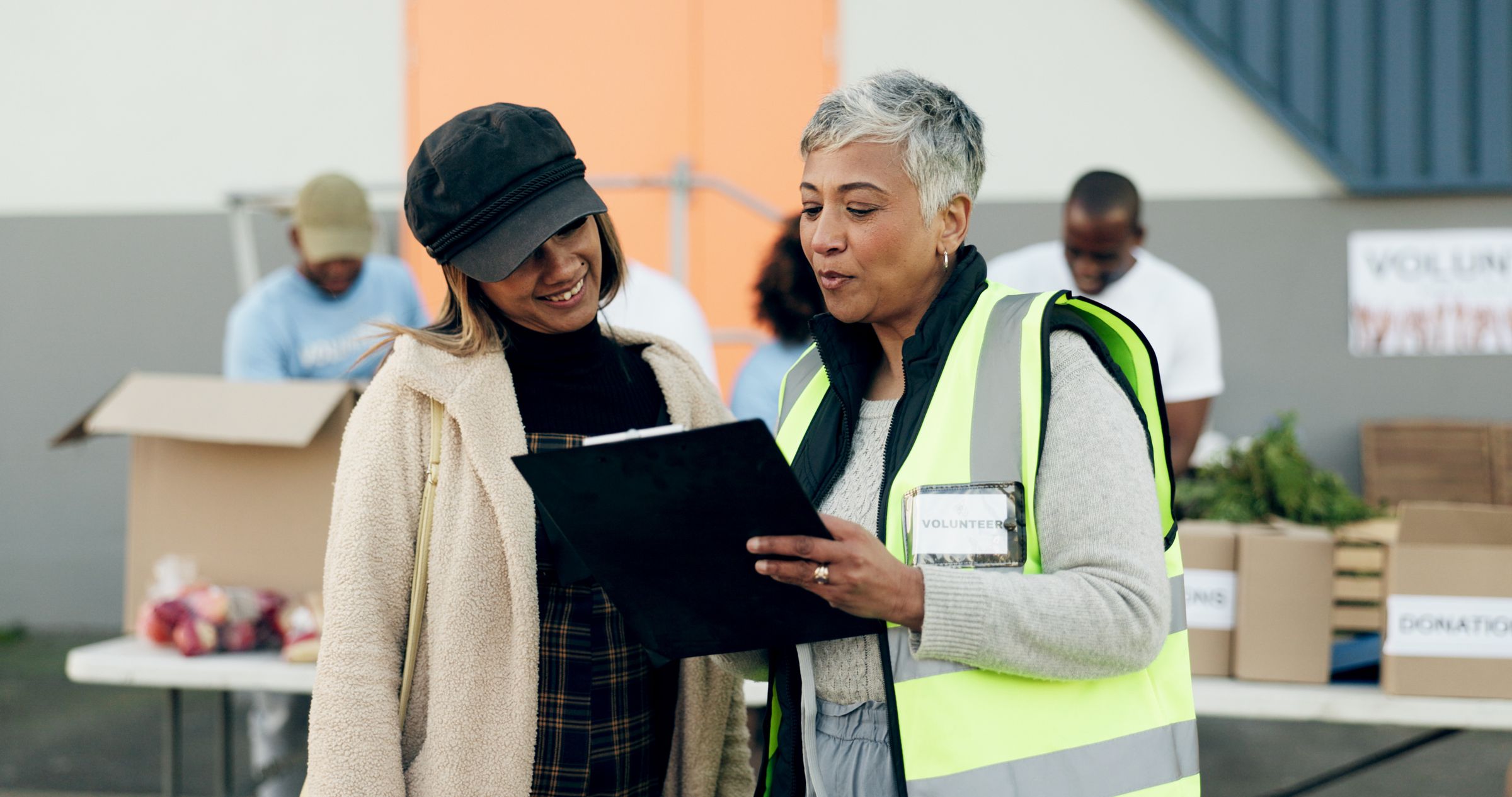 A volunteer and a community member reviewing a form together at a food distribution